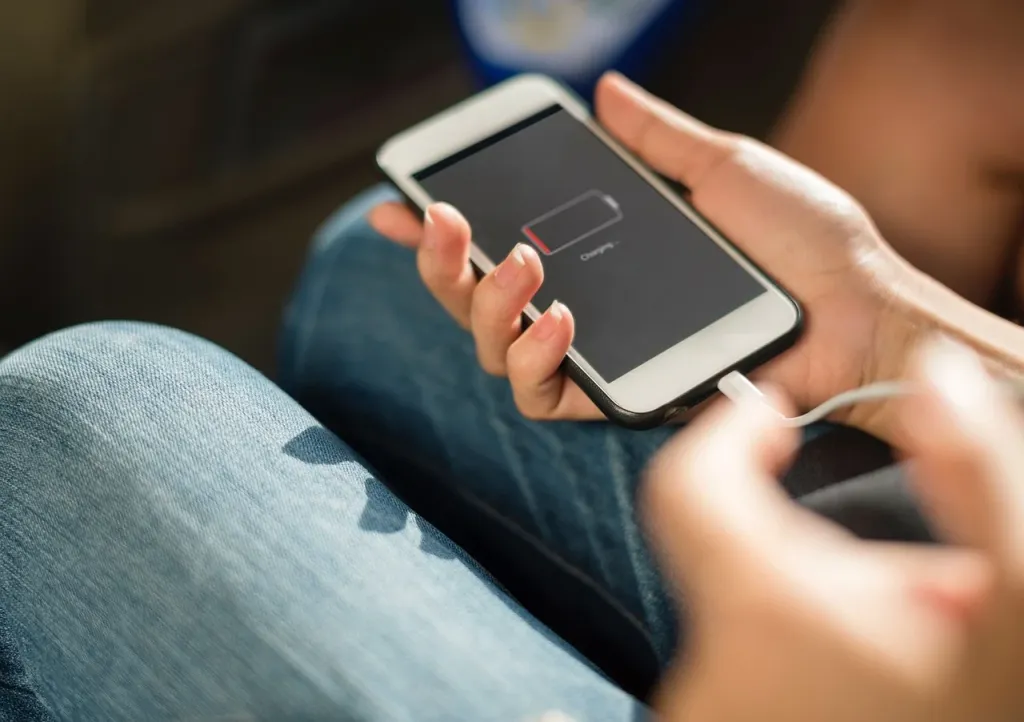 Smartfon leżący na biurku z widocznym wskaźnikiem kondycji baterii na poziomie 85 procent.